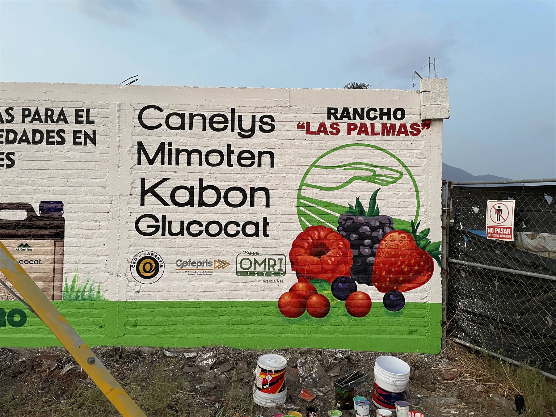 Barda rotulada a mano con marcas de productos agrícolas y frutas ilustradas.