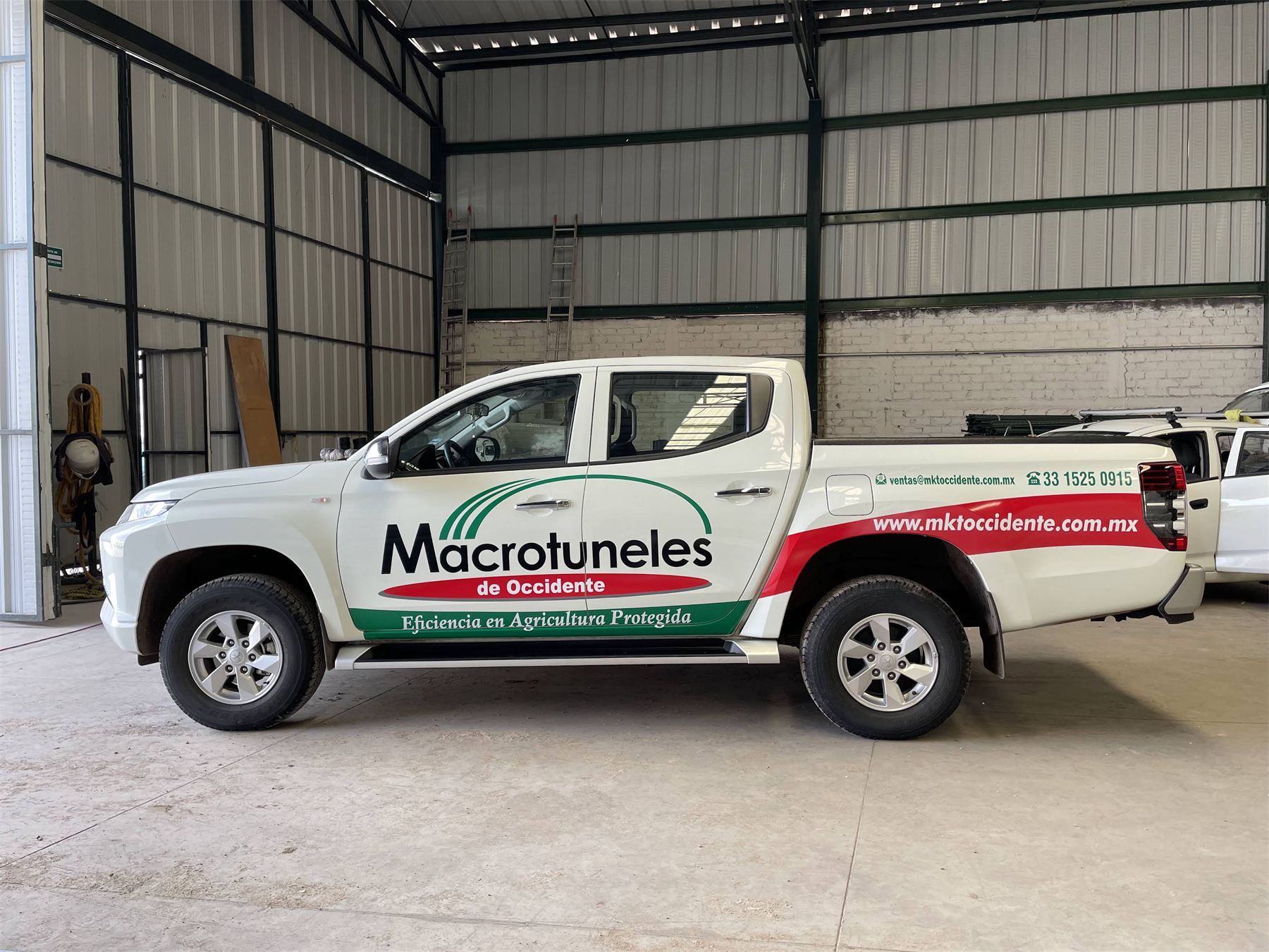 Camioneta pick-up blanca rotulada con la marca Macrotuneles.