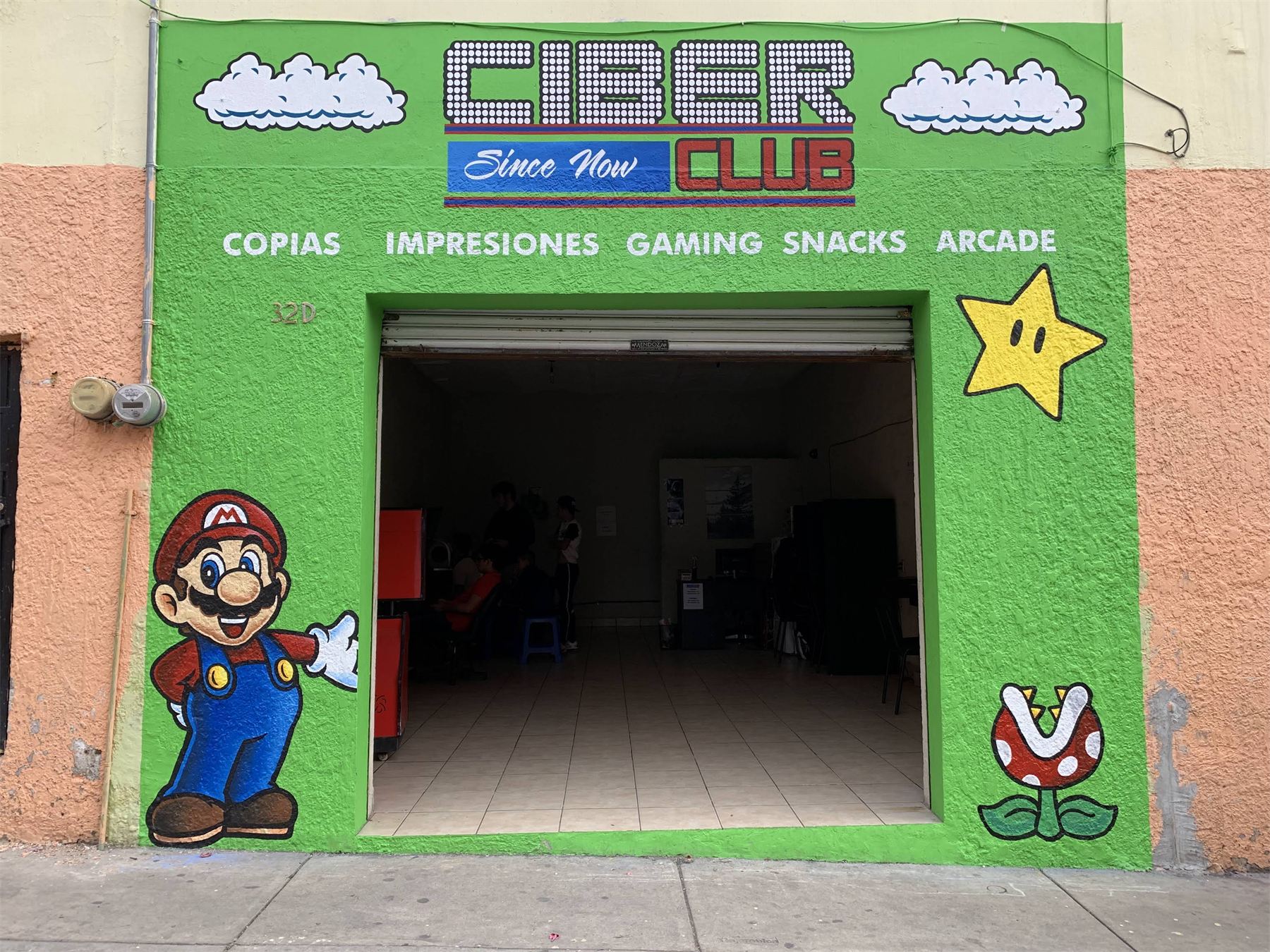 Fachada de ciber pintada en verde con personajes de videojuego.