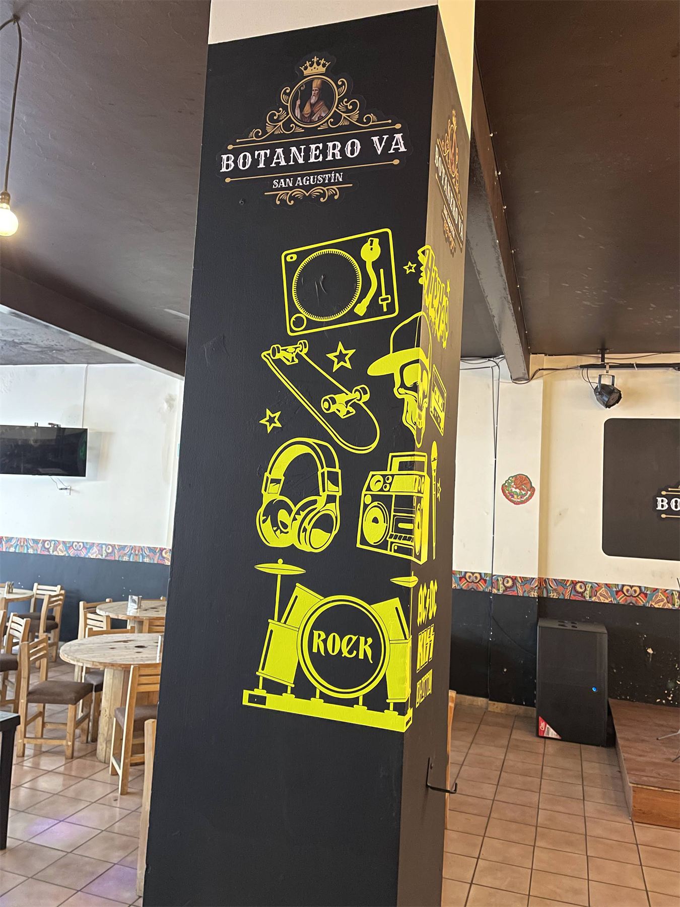 Columna interior de un restaurante forrada con vinil ilustrado en amarillo.