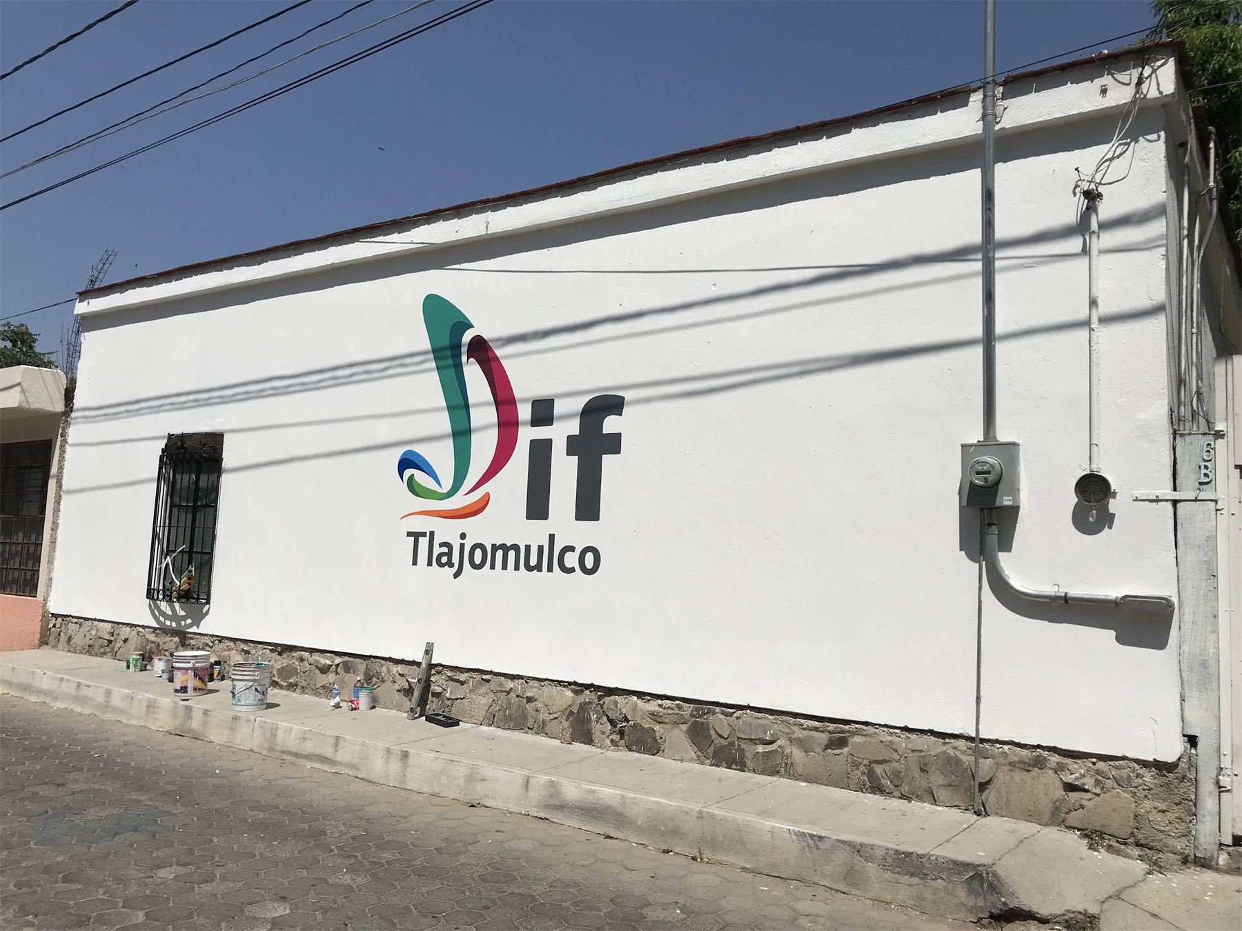 Logotipo del DIF Tlajomulco rotulado sobre un muro blanco.