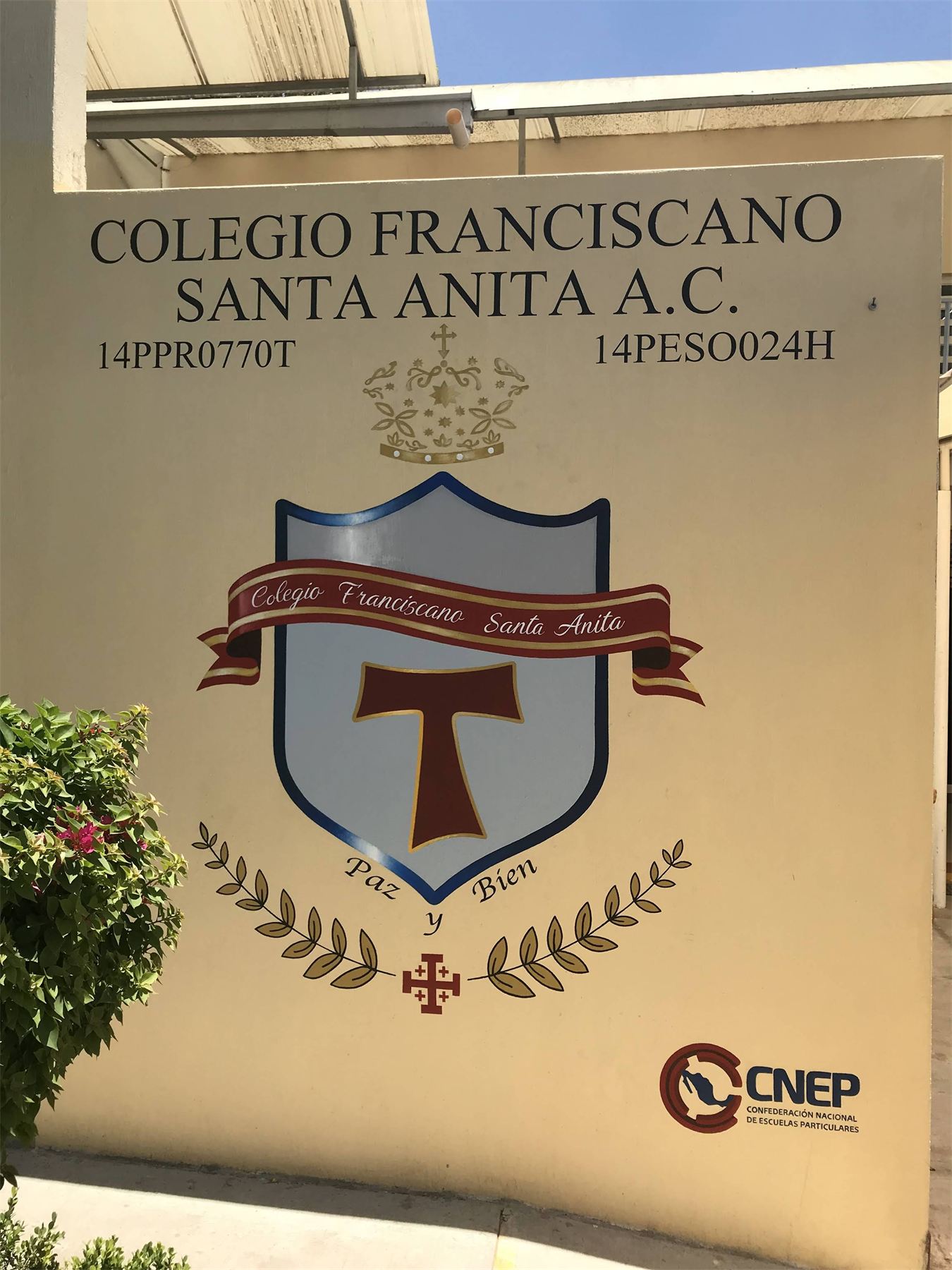Escudo y nombre del Colegio Franciscano Santa Anita rotulados sobre muro.