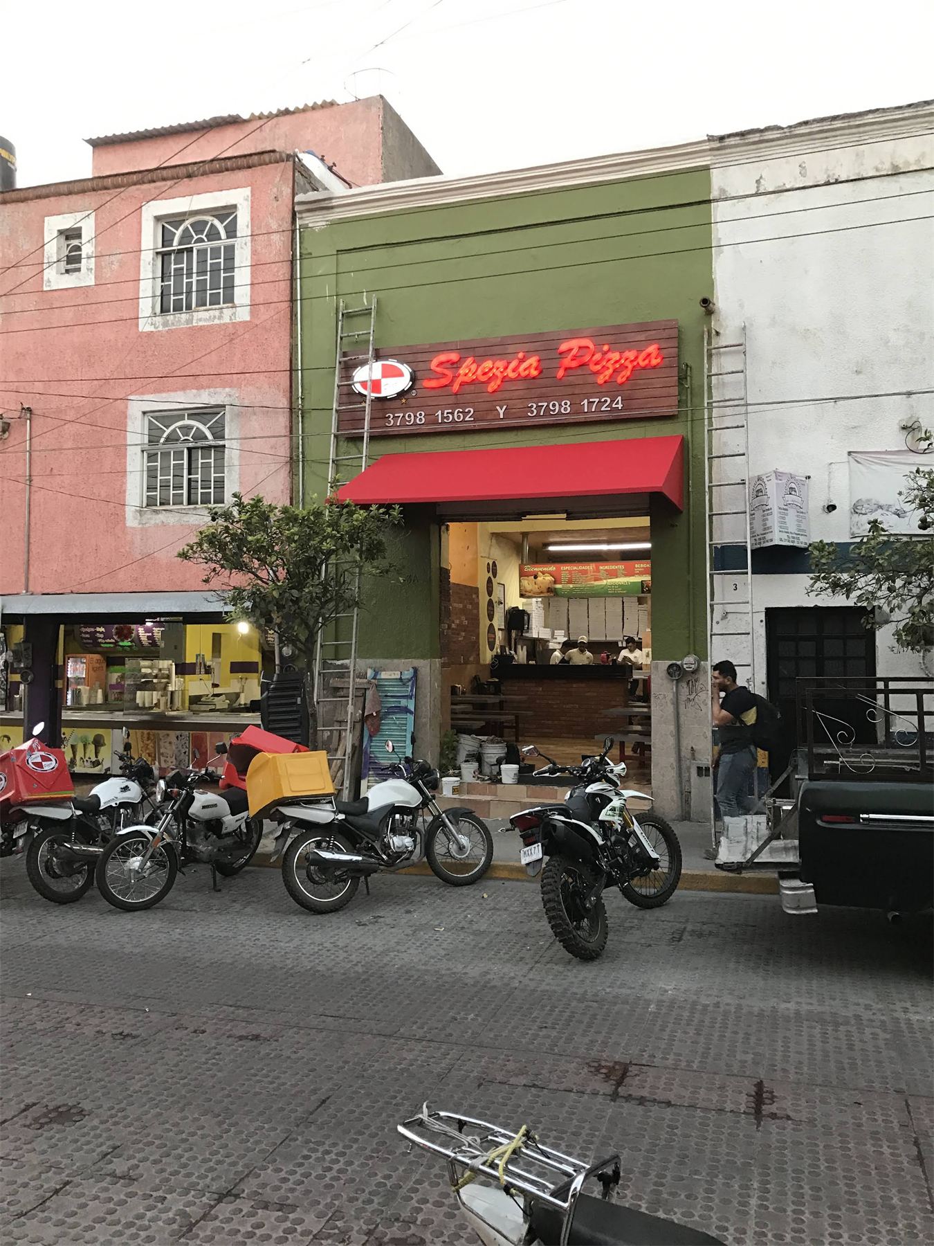 Local comercial con letrero rojo de pizzería.