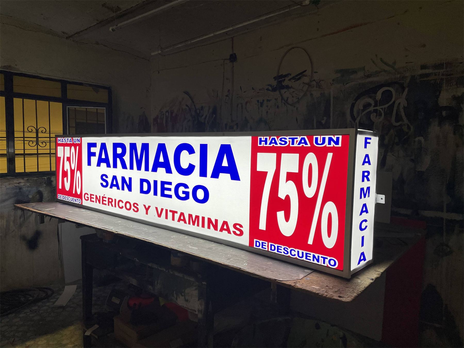 Letrero luminoso de la Farmacia San Diego con promoción.