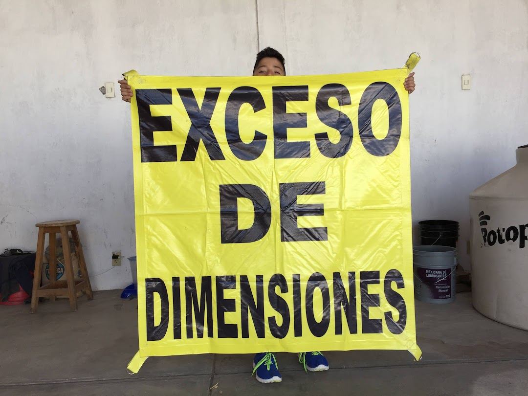 Lona amarilla con la leyenda Exceso de dimensiones en letras negras.