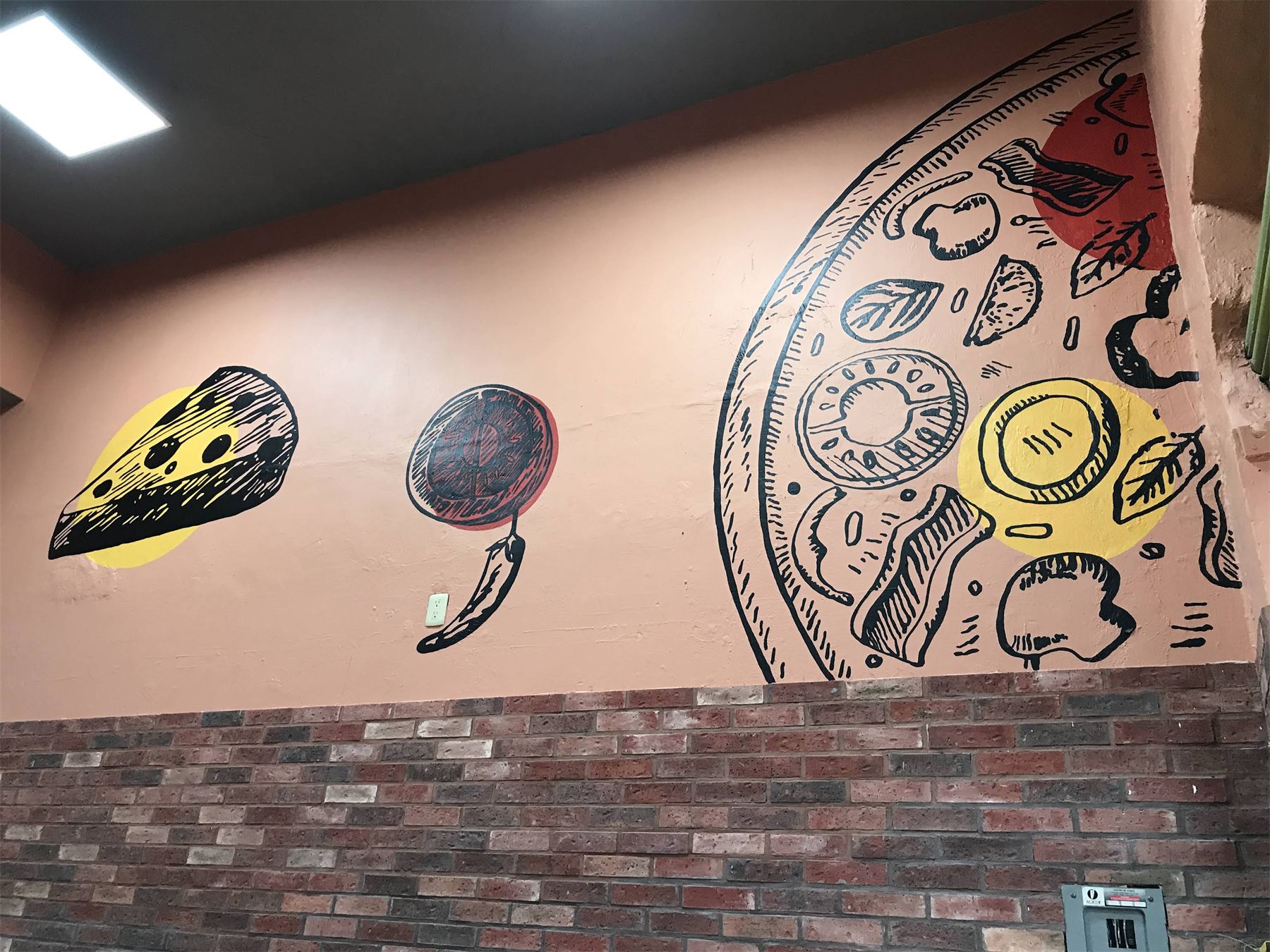 Mural ilustrado con ingredientes de pizza sobre un muro interior.