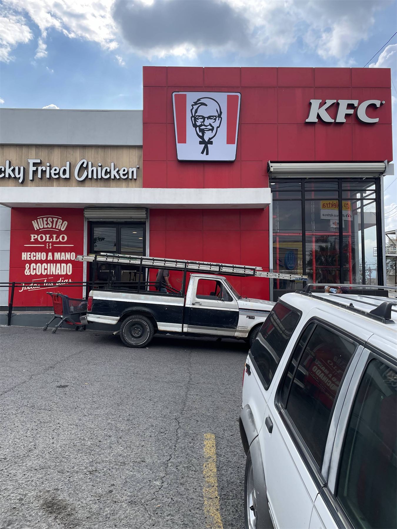 Fachada de KFC con letrero y señalética de la franquicia.