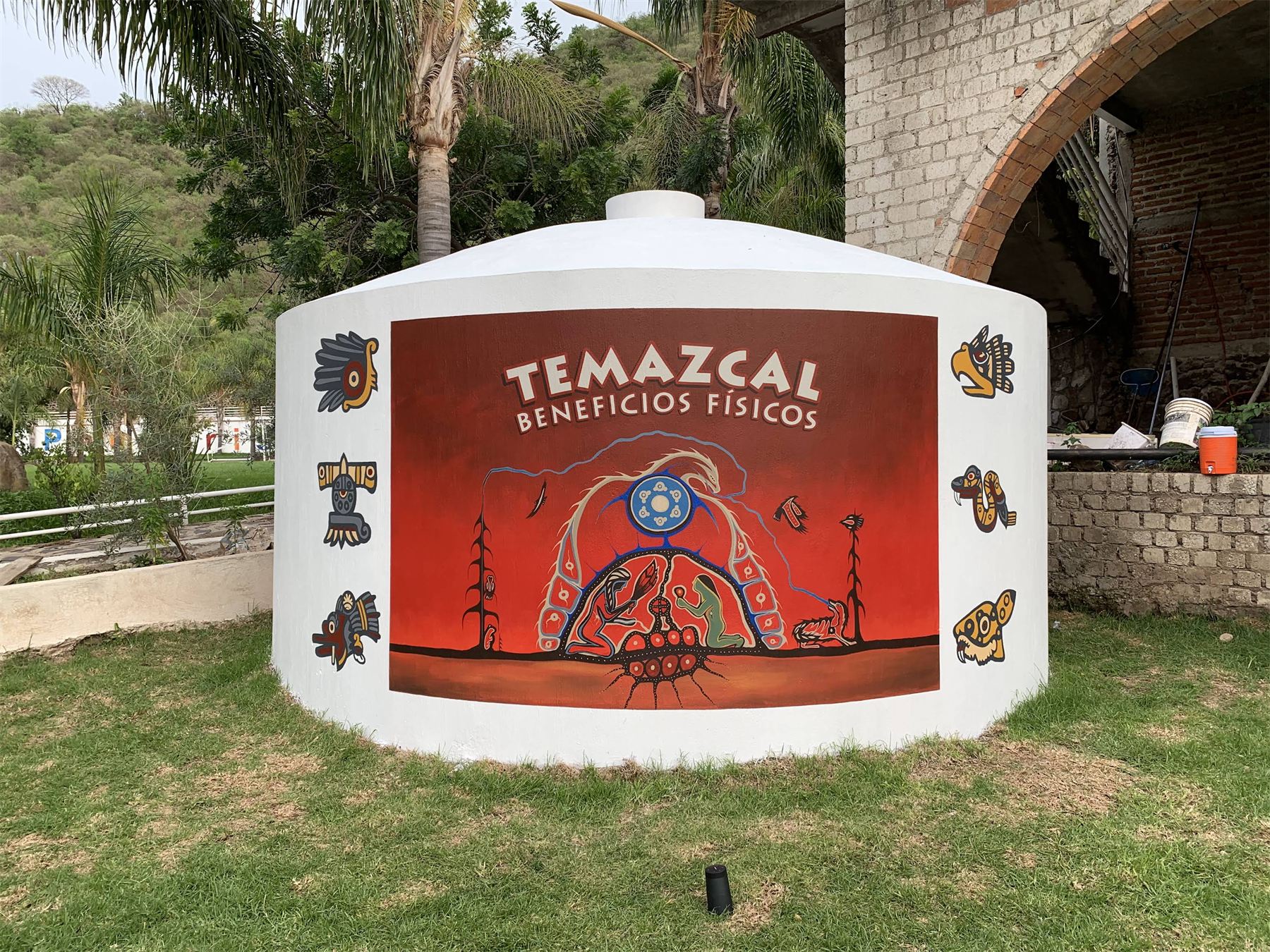 Construcción circular de temazcal con mural decorativo y rotulación.