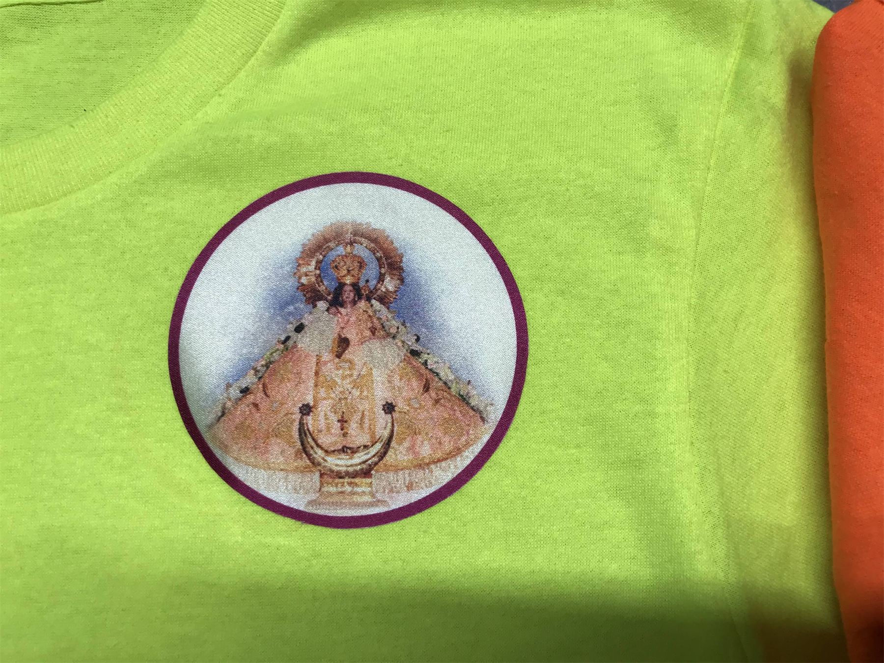 Imagen de la Virgen pintada dentro de un círculo sobre tela verde.